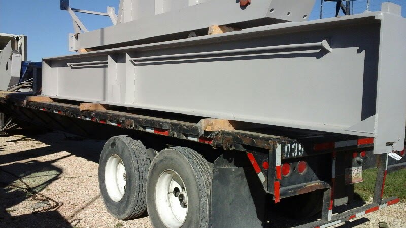 Refurbished steel assembly secured on a flatbed trailer