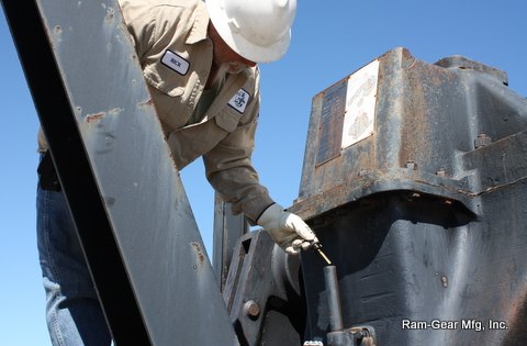 Technician checking gearbox oil level on location